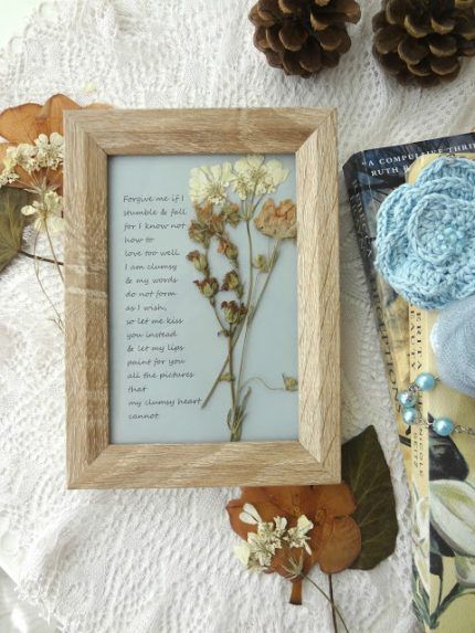 a wooden frame sitting on top of a table next to pine cones and other items