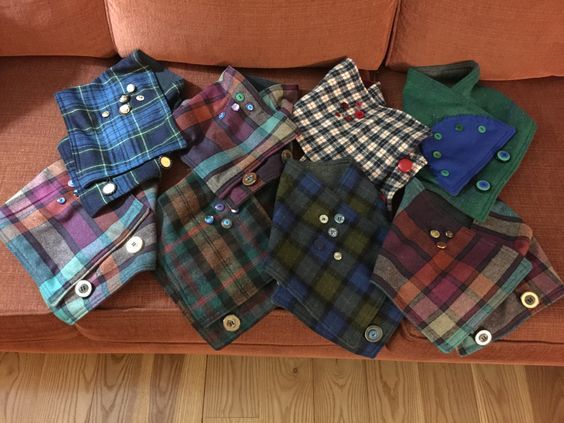 a pile of different colored shirts sitting on top of a couch