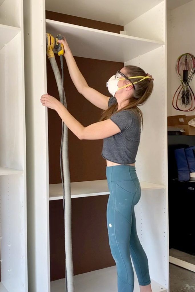 a woman in tights and goggles working on a bookcase with a pair of scissors