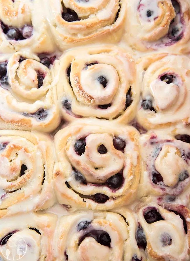 blueberry cinnamon rolls with icing in a pan