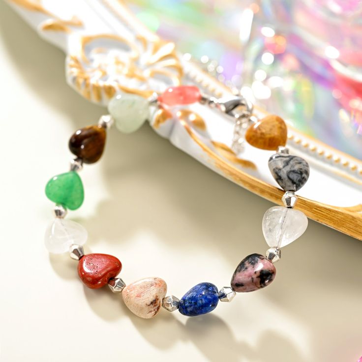 Experience elegance and playfulness with our Natural Stone Heart Beaded Bracelet! This bracelet showcases a stunning array of heart shaped natural stones, each one carefully selected for its unique hue and texture. Each colorful stone is handpicked to inspire unique beauty. Perfect for holidays and beach adventures in a hot summer day. Show your love for nature with this one of a kind piece! DETAILS Materials: Brass, Natural Stones Measurements: Length: 6.69"(17cm)+Extender: 1.57"(4cm) Weight: 1 Heart-shaped Beaded Bracelets With Natural Stones For Gift, Heart-shaped Natural Stone Beaded Bracelets For Gifts, Heart-shaped Natural Stone Beaded Bracelets As Gift, Heart-shaped Natural Stone Beaded Bracelet Gift, Spiritual Heart Beads Bracelet Gift, Heart-shaped Adjustable Gemstone Beads Bracelet, Heart-shaped Healing Beaded Bracelets, Heart-shaped Beaded Bracelets With Natural Stones For Healing, Heart-shaped Natural Stone Beaded Bracelets For Healing