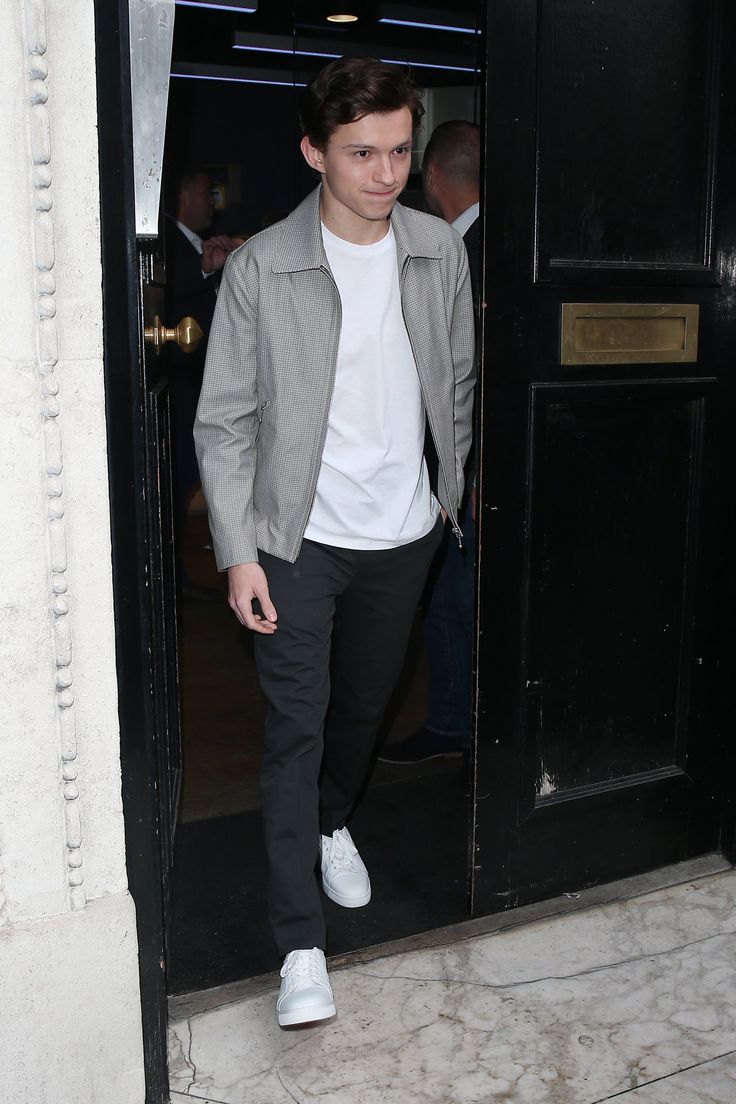 a young man walking out of a black door with his foot in the open pocket