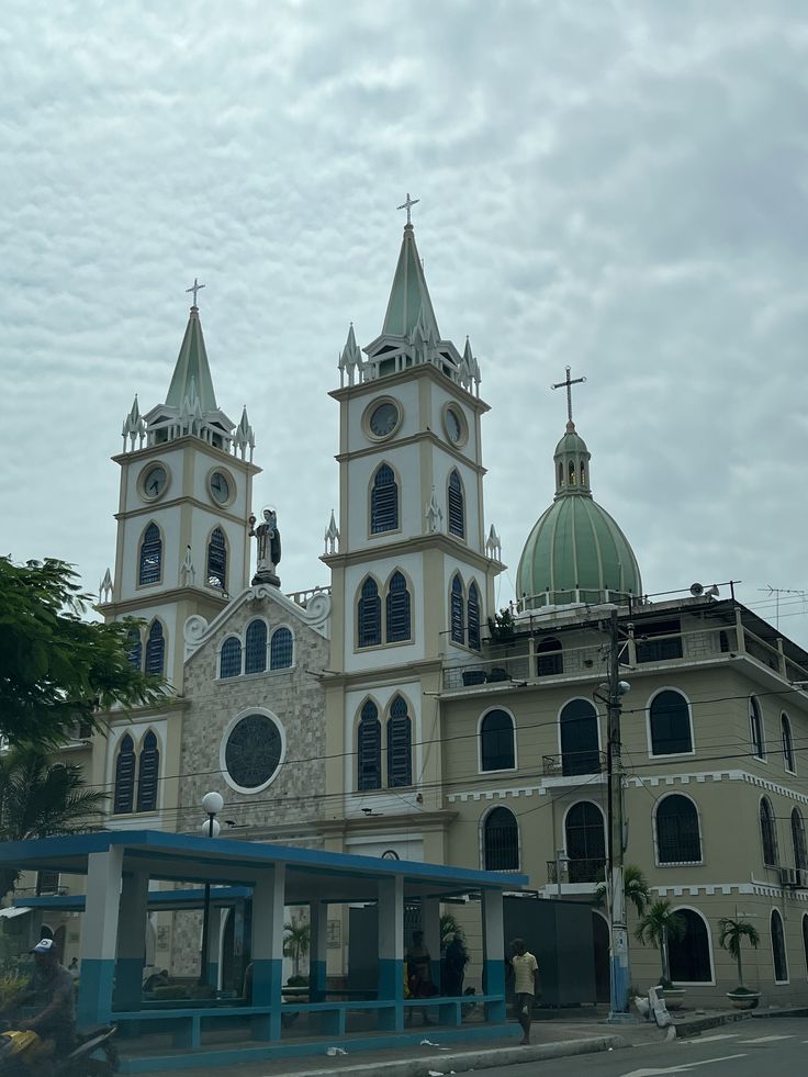 an old church with two towers and three steeples on the top, in front of a cloudy sky