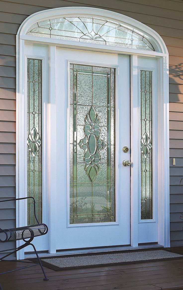 the front door is decorated with glass and has a bench on the side walk way