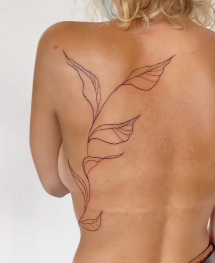 a woman's back with a tattoo on it