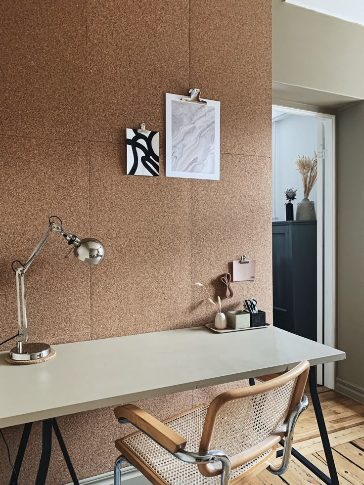 a desk with a chair, lamp and pictures on the wall