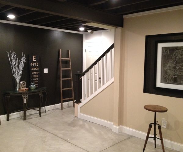 an empty room with black walls and white stairs