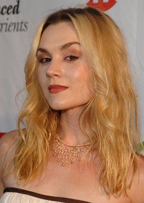 a woman with long blonde hair wearing a choker and dress at an awards event