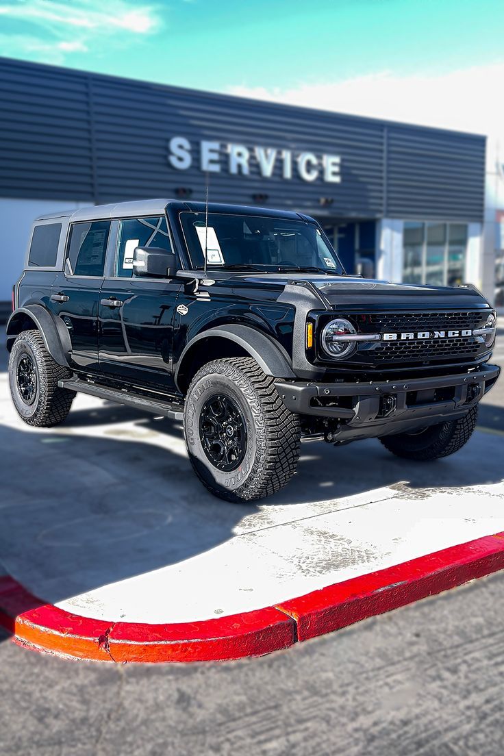 a black truck parked in front of a service building