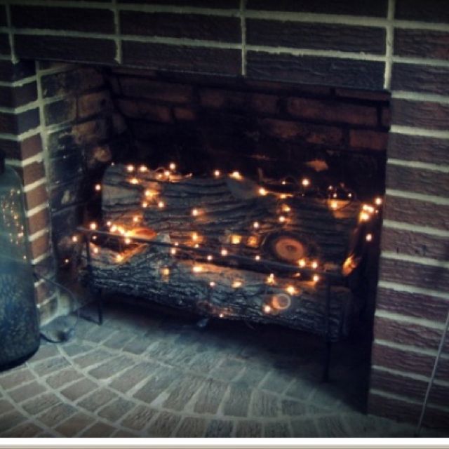 a fire place that has some lights on it and is lit up in the dark