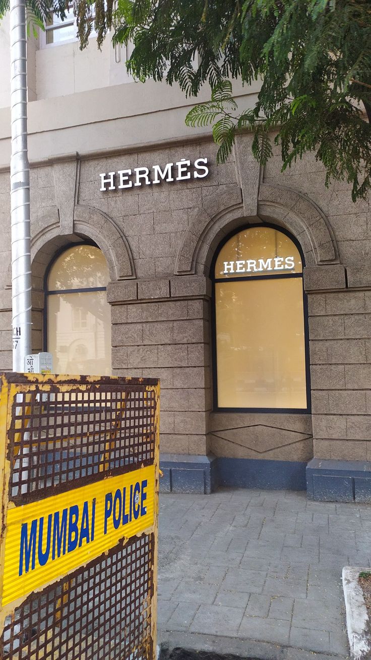 there is a yellow barricade in front of the building that says hermes