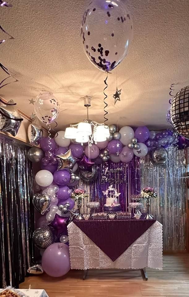 a party room with balloons, cake and decorations