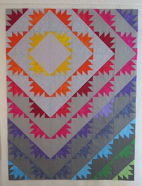 a colorful quilt hanging on the wall