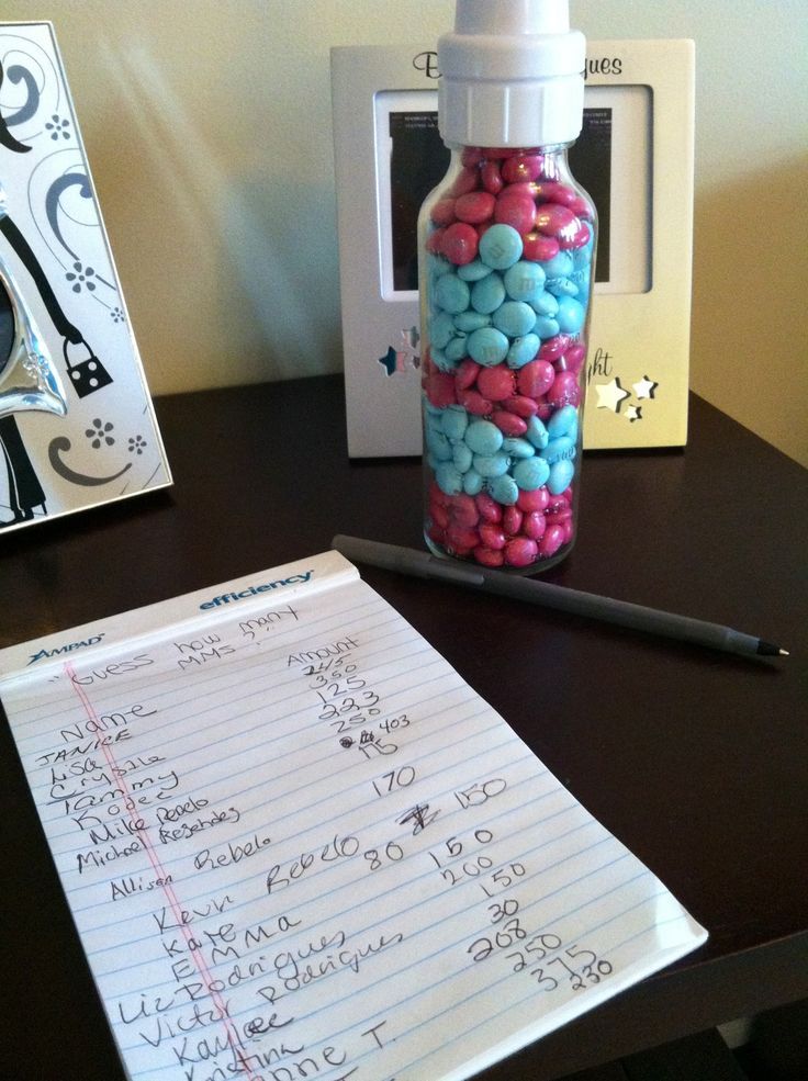 a bottle filled with candy sitting on top of a desk next to a notepad