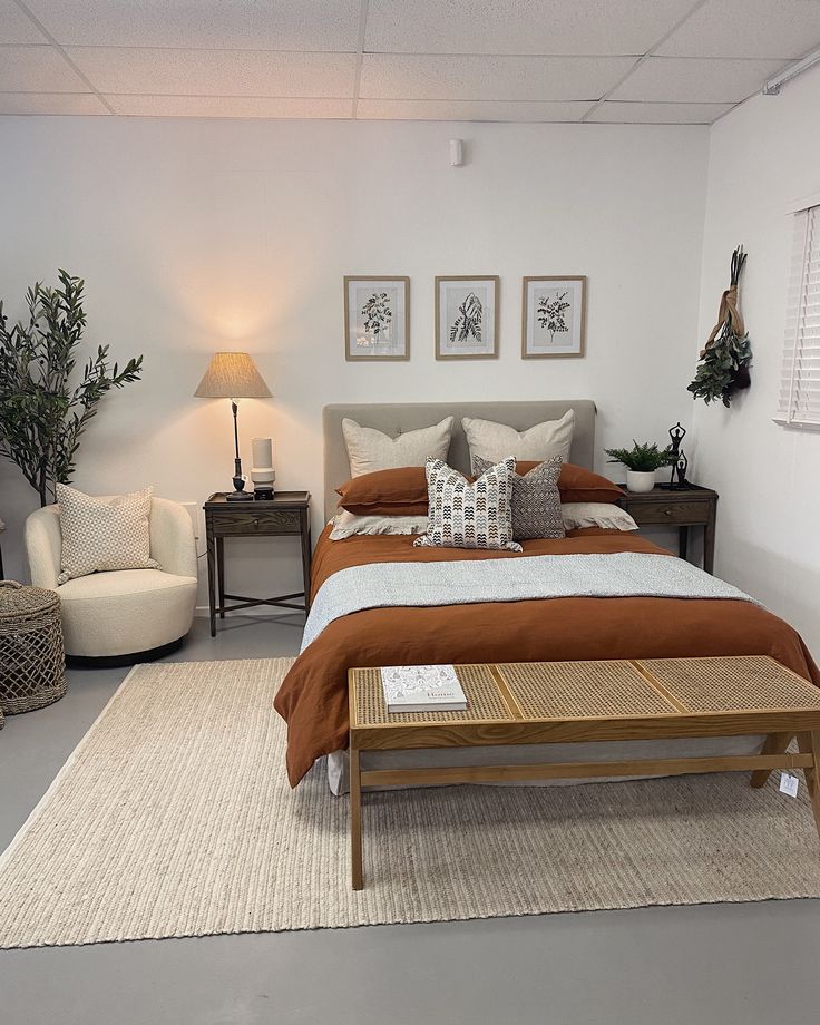 a bed room with a neatly made bed next to two chairs and a coffee table