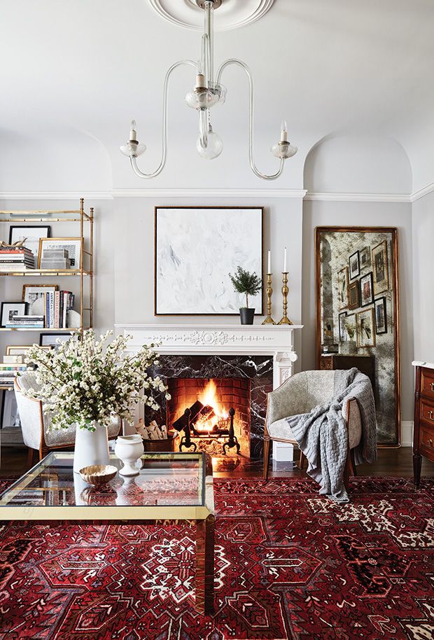 a living room filled with furniture and a fire place under a chandelier above a fireplace