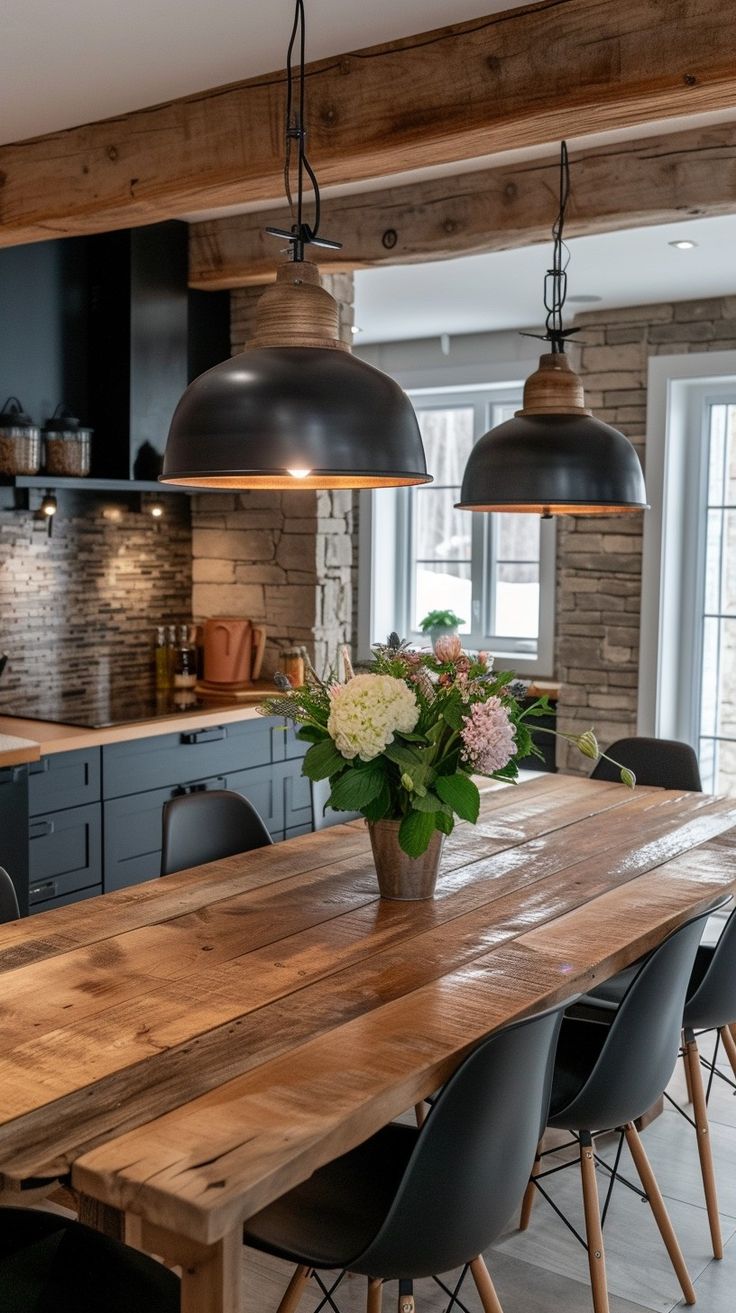 a large wooden table sitting under two hanging lights in a kitchen next to a window