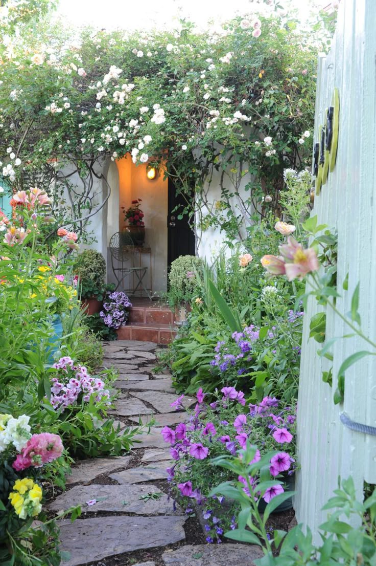 an open door leading into a garden filled with flowers