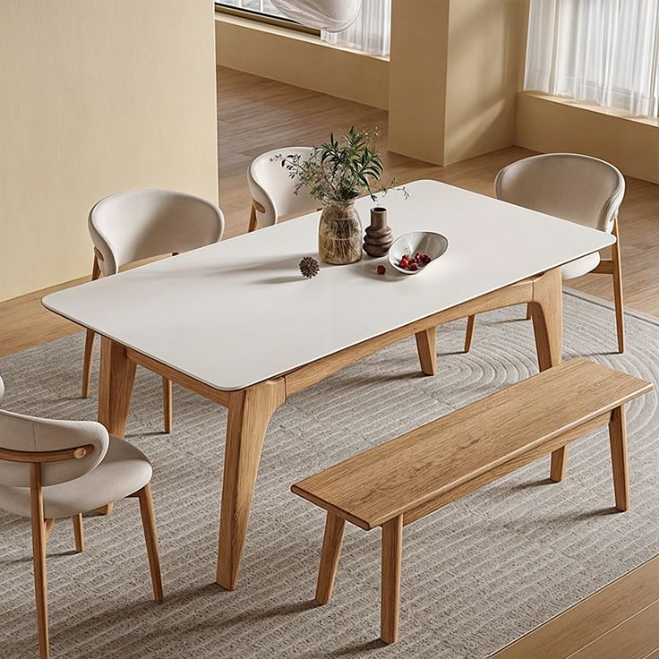 a white table with four chairs and a bench in front of it on carpeted flooring