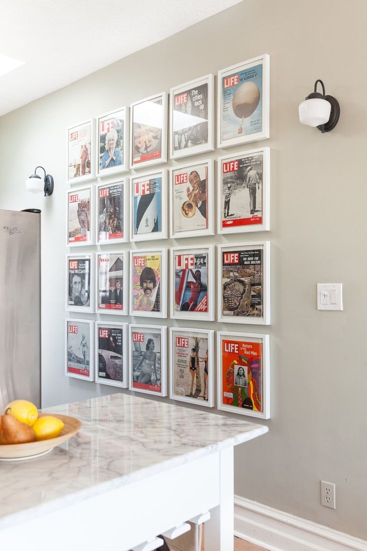 a kitchen counter with magazines on the wall and oranges on the plate next to it