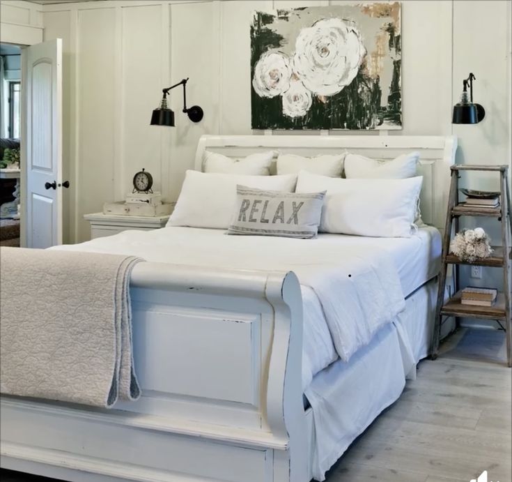 a bed with white linens and pillows in a room that looks like it has been decorated