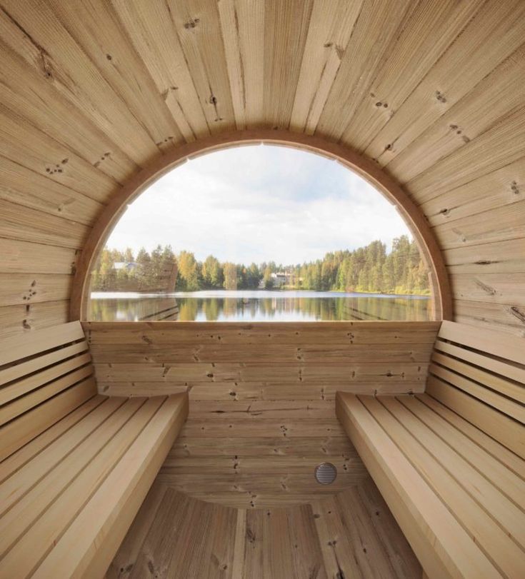 the inside of a wooden sauna with benches and a lake in the back ground