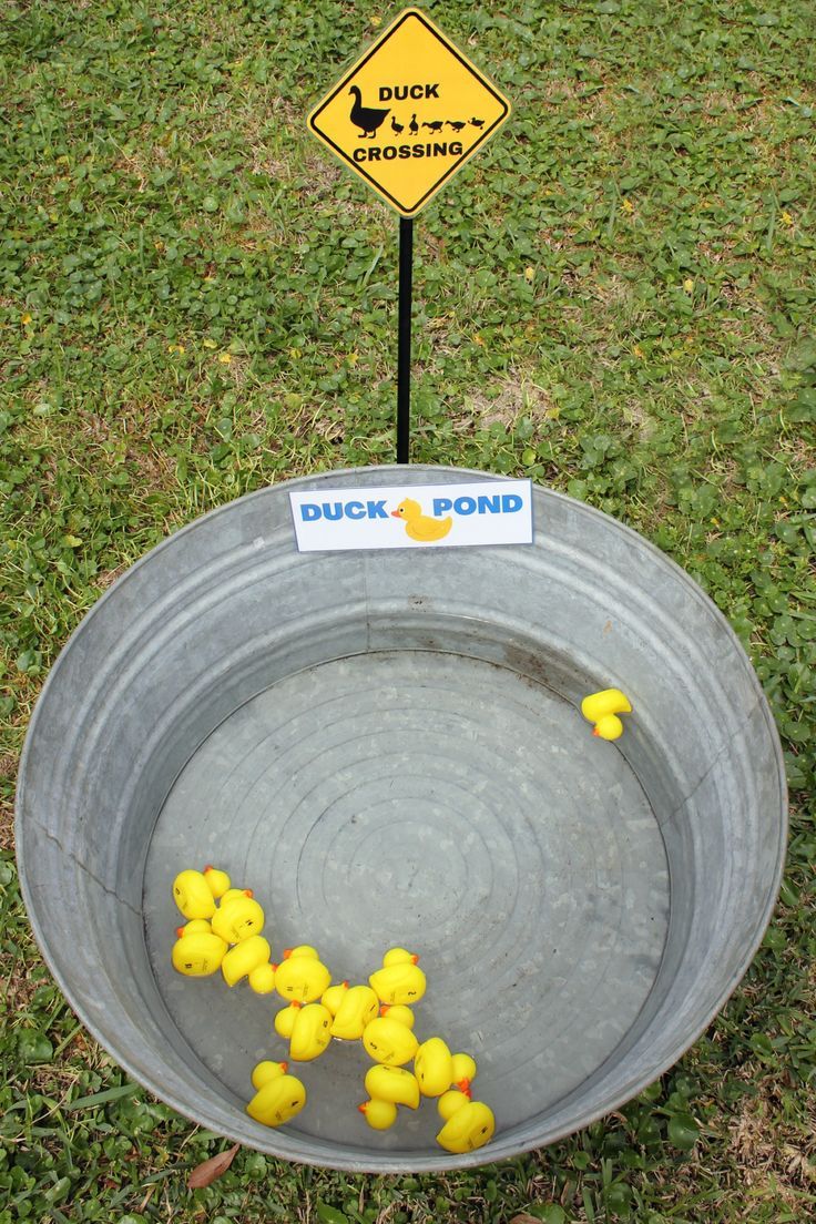 a metal bowl with yellow rubber ducks in it and a duck crossing sign on the side