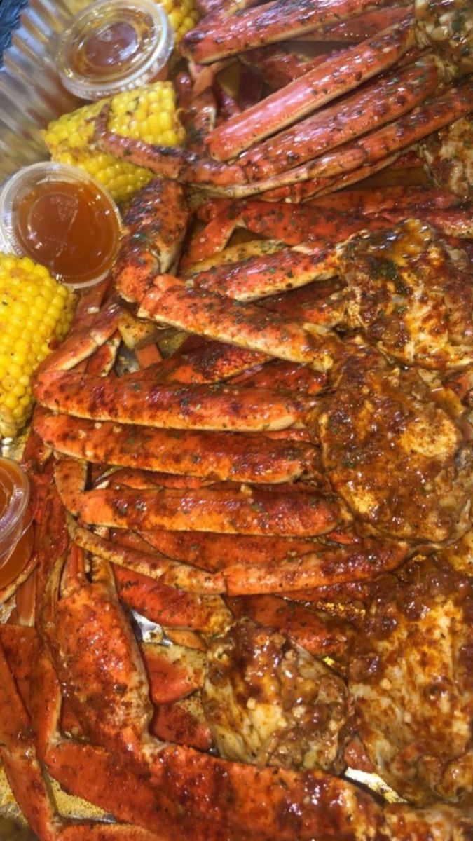 there are many different types of food on this platter, including lobsters and corn