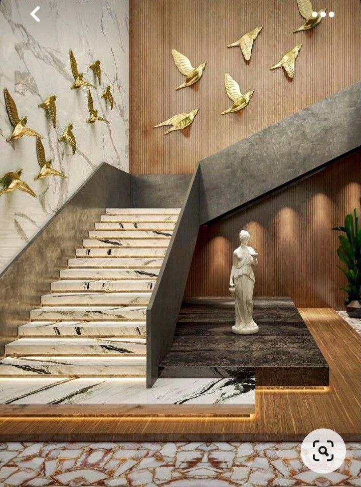 the stairs are made of marble and have gold leaf decorations on them, along with a statue of a woman