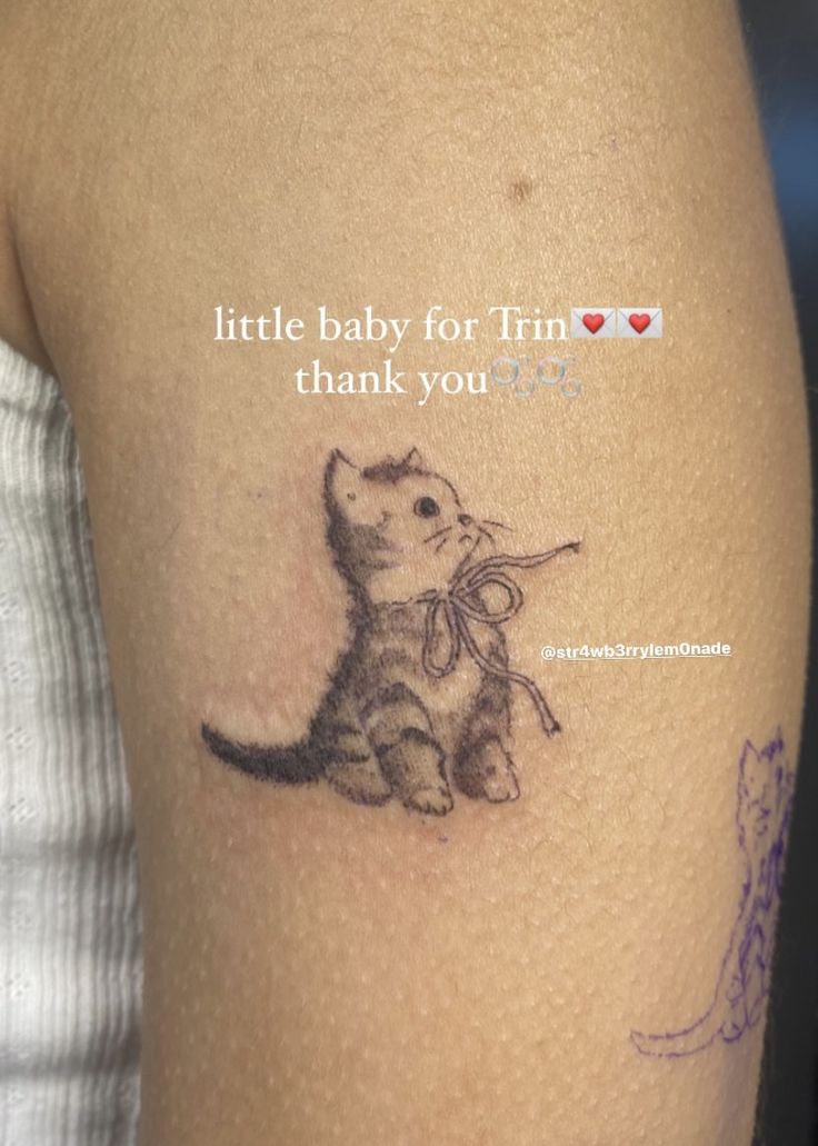 a little baby cat tattoo on the arm