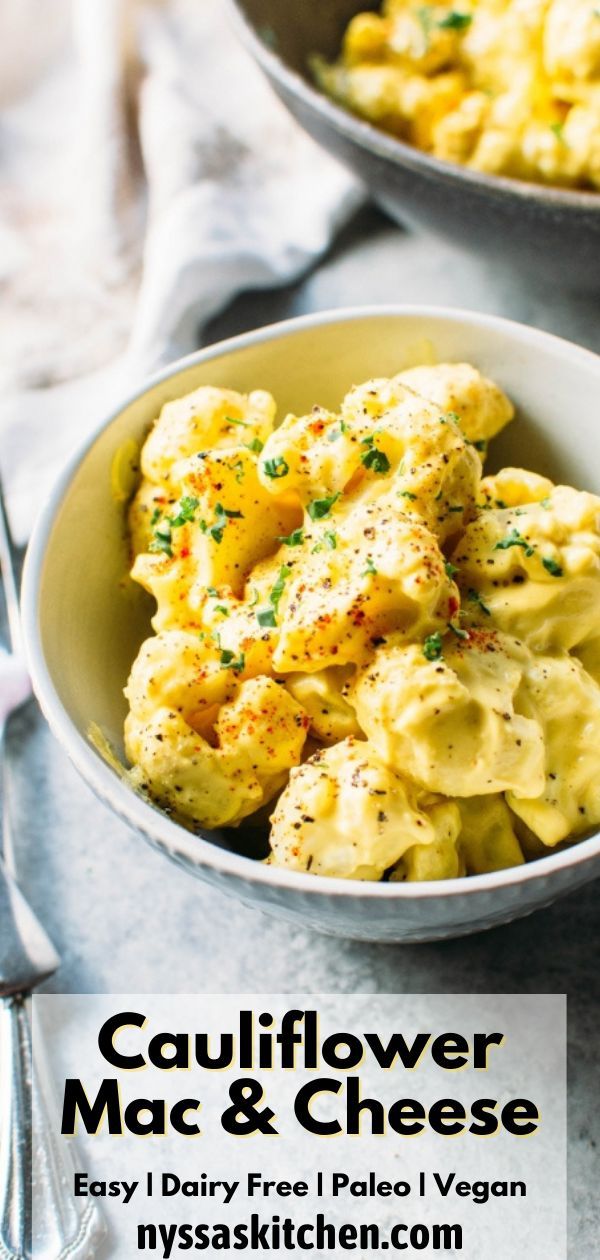 two bowls filled with macaroni and cheese on top of a table next to silverware