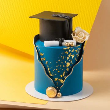 a blue graduation cake with gold sprinkles and a black cap on top