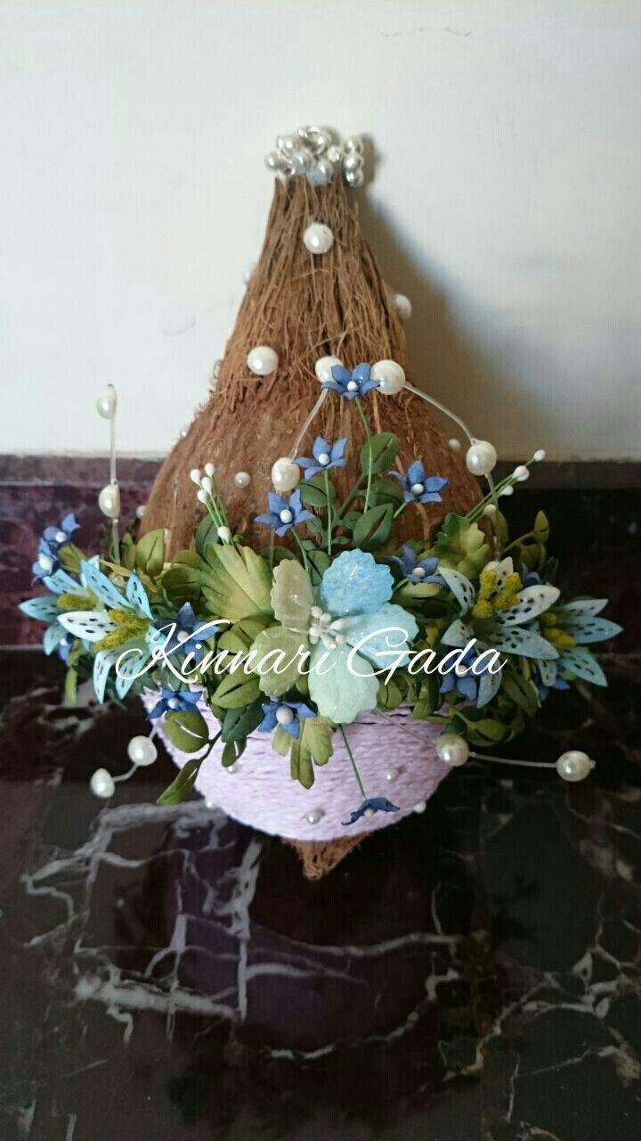 an arrangement of flowers in a pink basket on a black table with white and blue accents