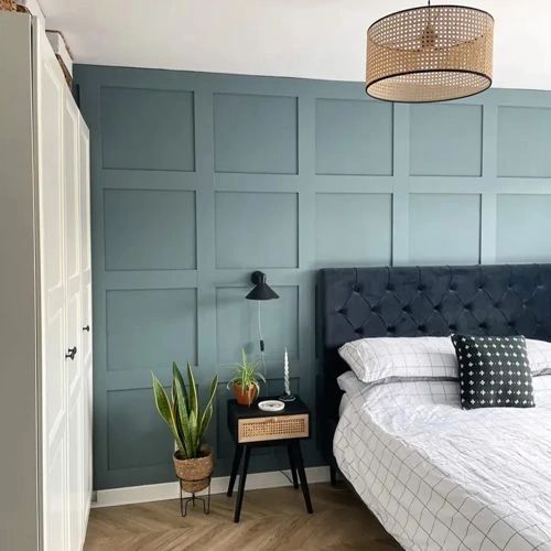 a bed sitting in a bedroom next to a wall with wooden paneling on it