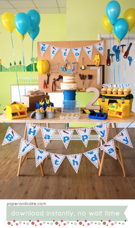 a birthday party with blue and yellow balloons on the wall, cake table and decorations