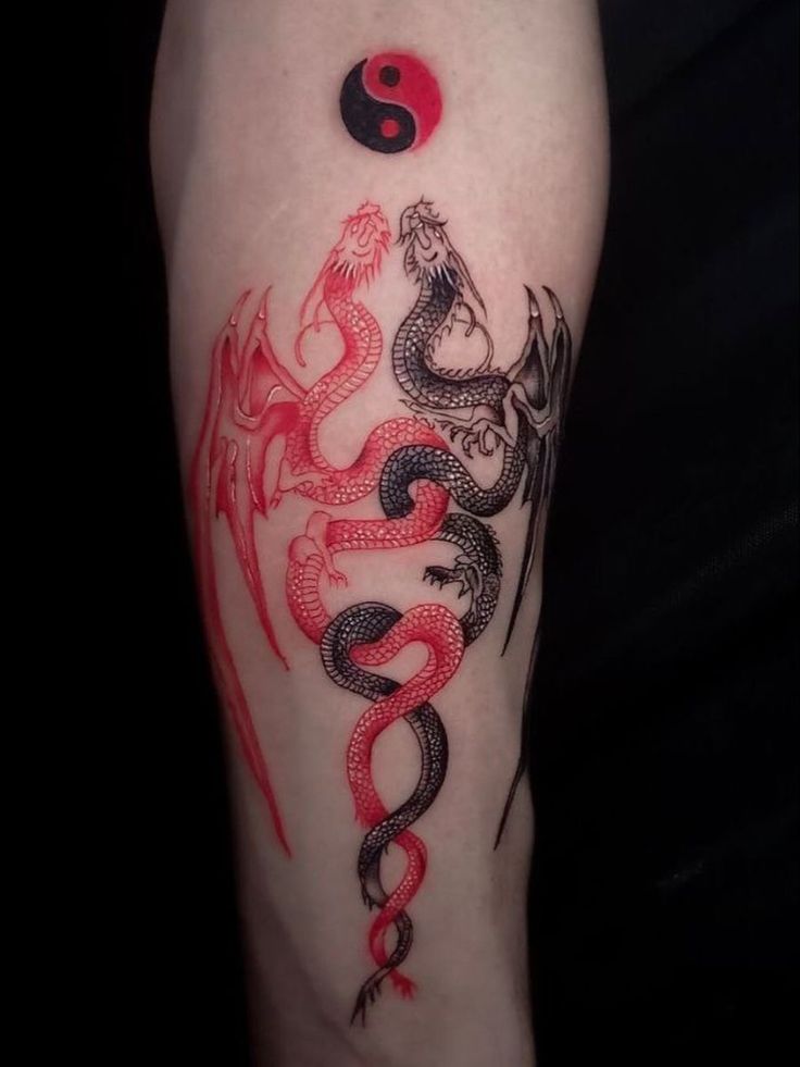 a red and black dragon tattoo on the arm