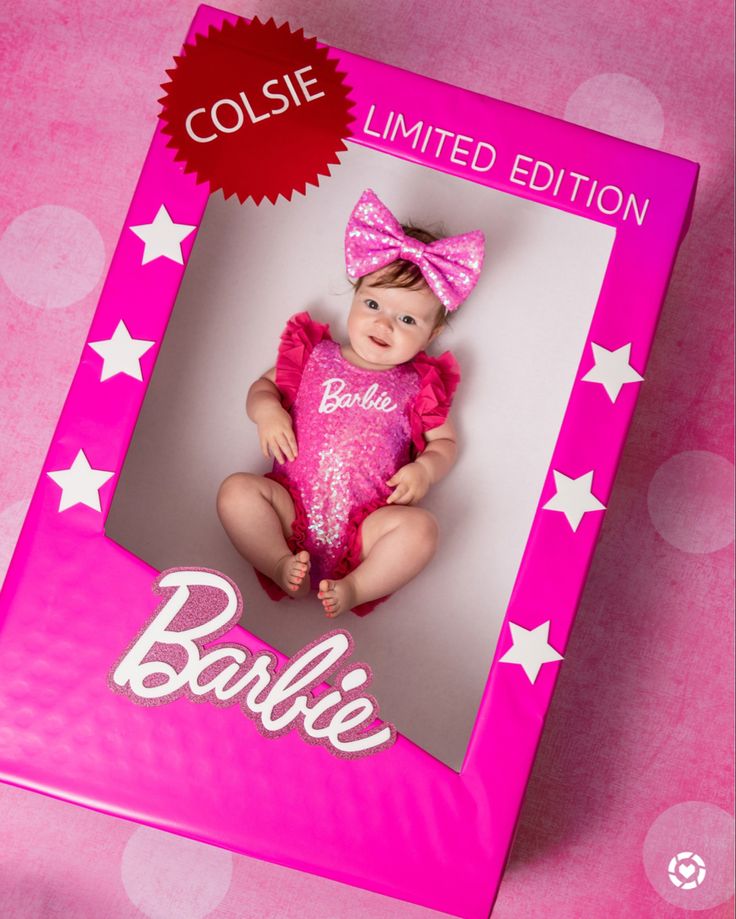 a baby doll is in a pink box with white stars on the cover and it's name barbie