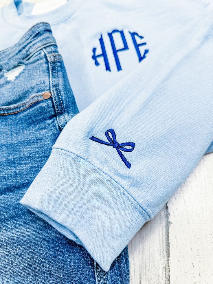 a pair of blue jeans with monogrammed letters on them and a t - shirt