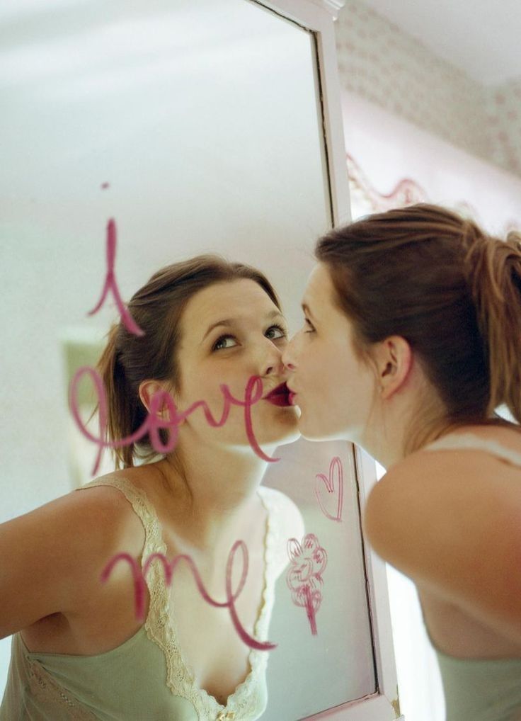 two women are looking at their reflection in the mirror and one has her mouth open