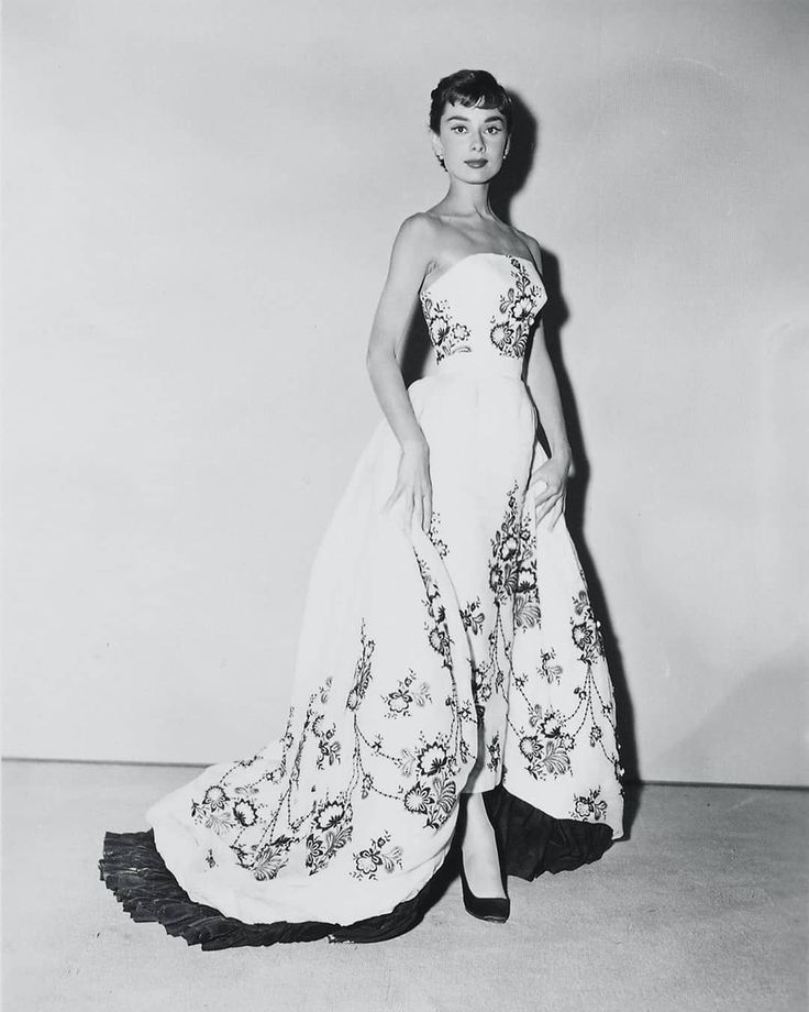 an old photo of a woman in a dress with flowers on the skirt and heels