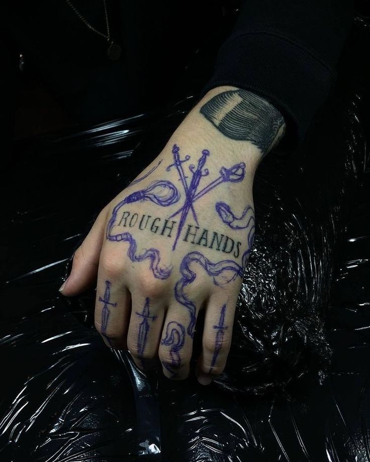 a person with a tattoo on their left hand and the words rough hands written in purple ink