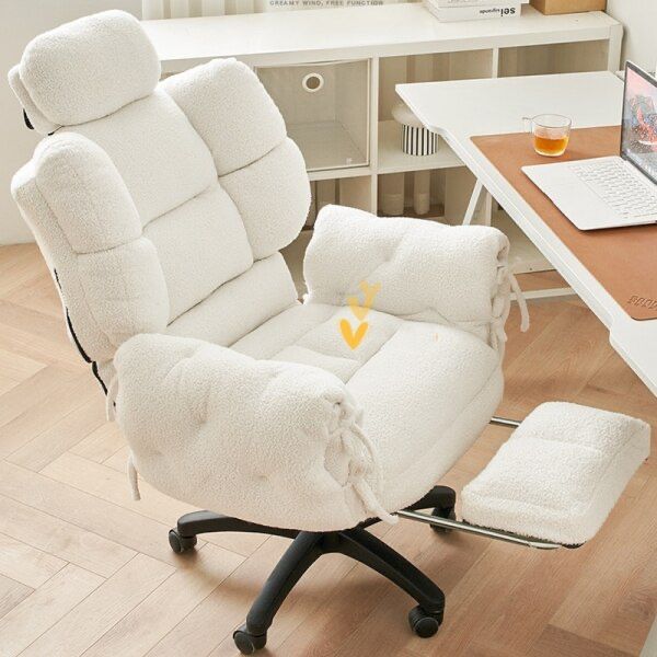 a white chair sitting on top of a hard wood floor next to a laptop computer