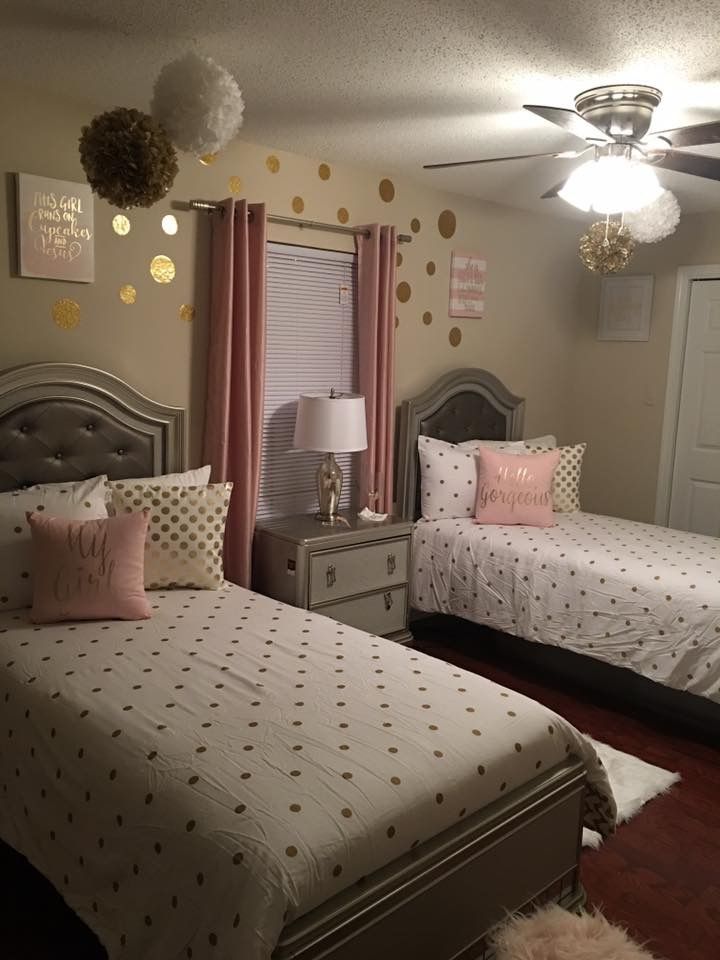 two twin beds in a bedroom with pink and gold decor