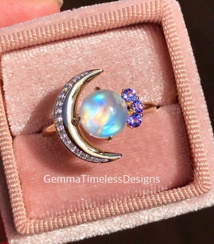 This new galaxy design is a gorgeous natural diamond, moonstone and tanzanite ring, it is perfect for an engagement ring or just a beautiful gift to someone special. The ring is made with 14K solid yellow gold, features a high quality cabochon moonstone (2.00ct, 8mm), side diamonds (approx 0.15ct total weight, Si clarity), natural tanzanites ( 0.12ct, vs clarity). Ring is in size 8.   **All our products will come with a certificate of authenticity provided by The Valuation Centre of Australia wh Moonstone Multi-stone Opal Ring As Gift, Multi-stone Moonstone Opal Ring For Gifts, Celestial Style Opal Gemstone Ring For Gifts, Celestial Style Opal Gemstone Ring Gift, Mystical Round Opal Ring For Anniversary, Celestial Style Opal Gemstone Ring, Mystical Opal Ring For Anniversary, Celestial Style Round Opal Ring, Celestial Opal Ring