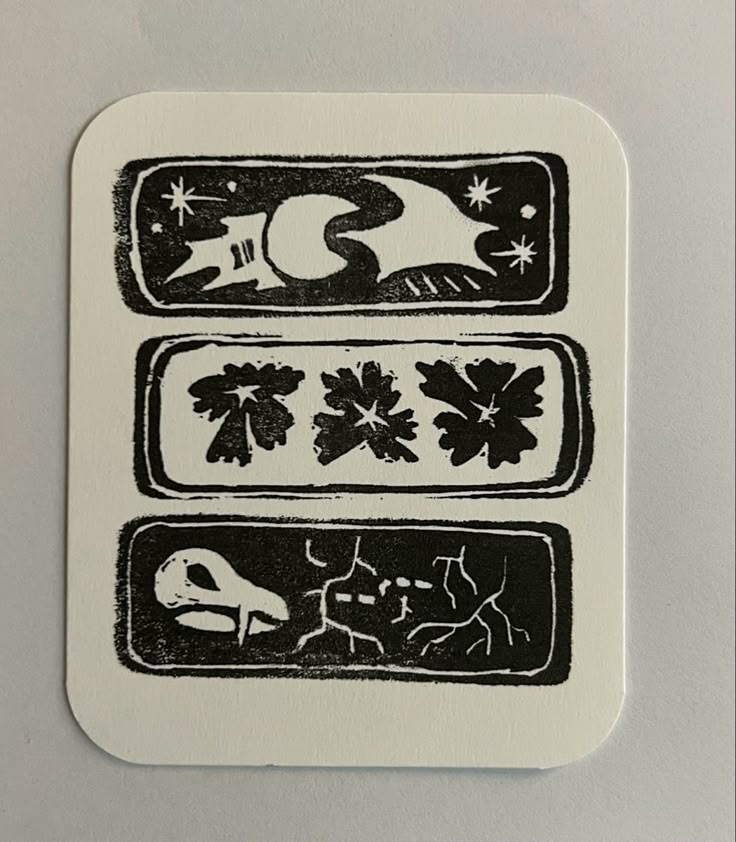 a white and black sticker with three different designs on the front, one has an image of a bird