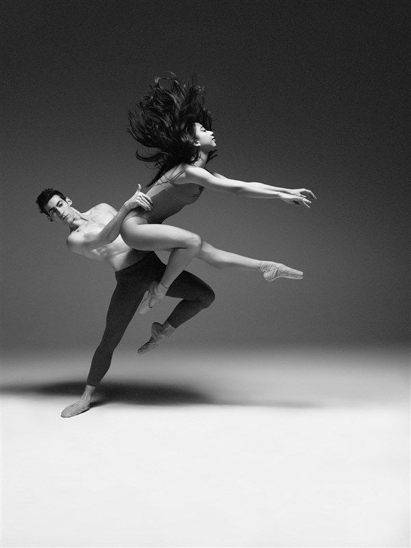 two dancers in black and white pose for the camera