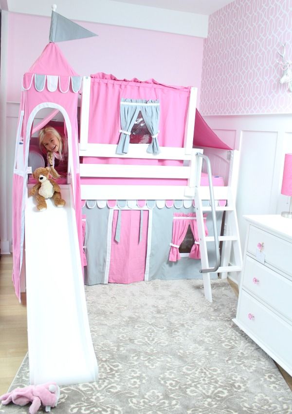 a child's bedroom with pink walls and white furniture, including a princess castle bed