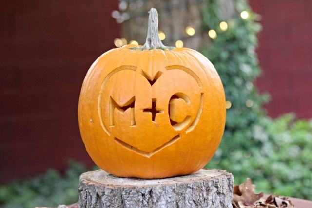 a carved pumpkin sitting on top of a tree stump