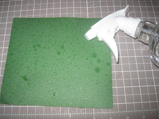 a close up of a spray bottle on top of a cutting board with green paper