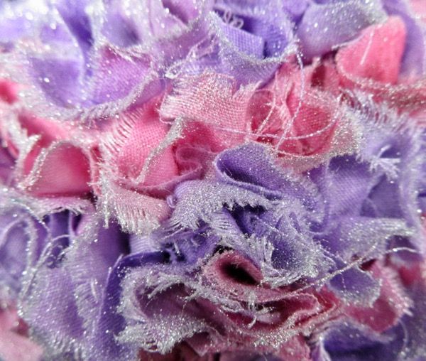 a close up view of the fabric on top of some cloth flowers with sequins